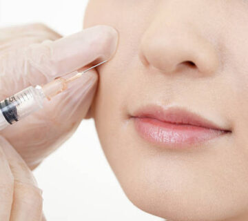 Doctor makes a cosmetic injection in her face