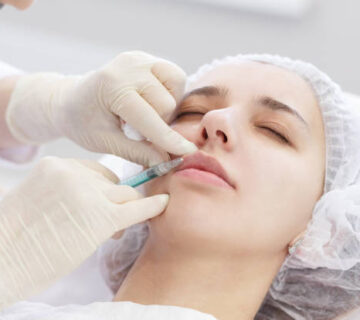 Plastic Surgery. Close up hans doctor in gloves doing Beauty Hyaluronic Lip Ingection. Young woman getting cosmetic treatment in cosmetology clinic.